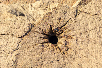 Hole with cracks in the seaside rock.