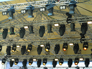 Spotlight devices in a row on  rigging steel trusses, installation of professional stage equipment.
