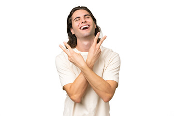 Young caucasian man isolated on green chroma background smiling and showing victory sign
