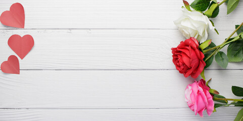 Flat lay, top view red, pink, white rose flowers, heart shaped paper on vintage wooden background with center copy space. Day of love concept such as valentine's day, mother's day, wedding, christmas.