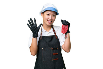 Young caucasian woman wearing an apron and serving fresh cut meat over isolated background counting five with fingers