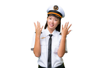 Airplane pilot Asian woman over isolated background counting nine with fingers