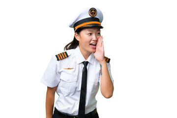 Airplane pilot Asian woman over isolated background shouting with mouth wide open to the lateral