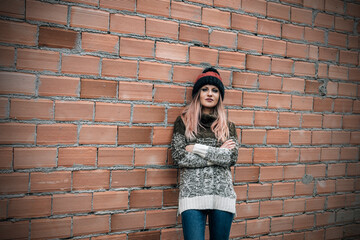 young urban hipster girl posing at the wall