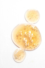Cosmetic texture of drops smear .with bubbles on white background.