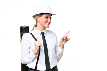 Young architect caucasian woman with helmet and holding blueprints over isolated background pointing finger to the side and presenting a product