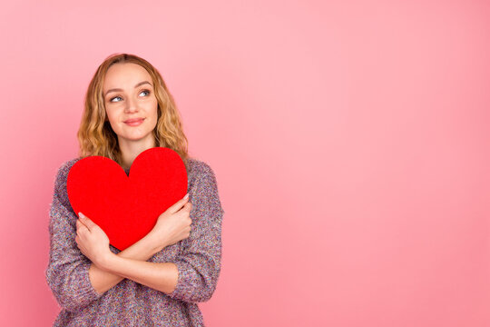 Photo of positive young happy woman hold hands cuddle heart shape look copyspace isolated on pink color background