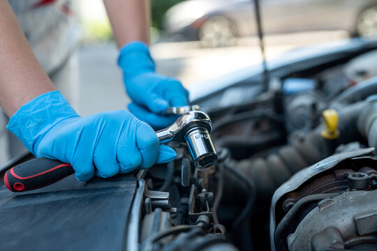 experienced female mechanic is servicing a car in her workshop.