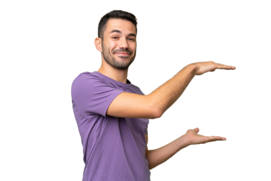 Young handsome caucasian man over isolated background holding copyspace to insert an ad