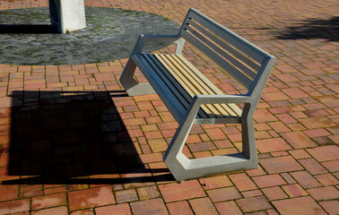 light concrete park bench, elegant cast frame and light wooden seat and backrest made of planks....