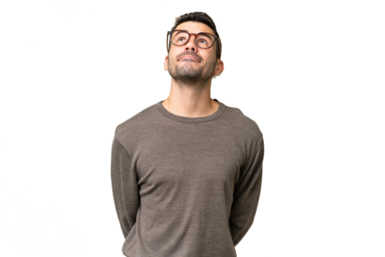 Young handsome caucasian man over isolated background and looking up