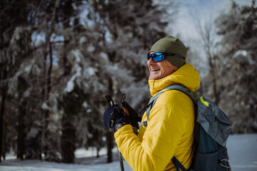 Fototapeta na wymiar Senior man admiring nature during cross country skiing.