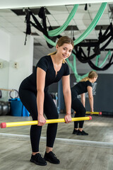 Fototapeta na wymiar Young athletic attractive woman doing exercises with pilates stick.