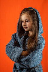 portrait of a beautiful little girl going to the shower in a gray bathrobe.