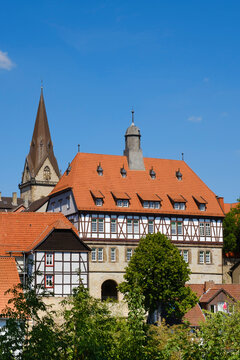 Germany, North Rhine-Westphalia, Warburg, Half-timbered town hall with church bell tower in background