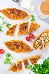 Turkish cheese pide, traditional flatbread pide, top view flat lay photo on stone background, concept photo tomato and parsley