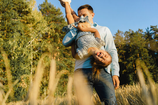 Happy father having fun with daughter at field - Powered by Adobe