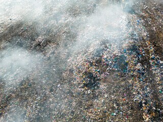 Aerial view of burning trash piles in landfill