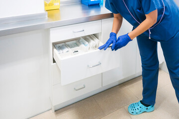 Mature nurse restocking medical supplies at hospital
