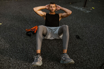 Fototapeta na wymiar Young man doing cardio exercises on sports ground during workout
