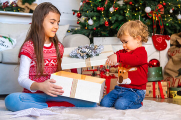 Children open Christmas gifts under the tree. Selective focus.