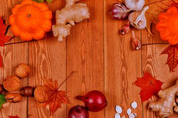 Still life with pumpkin - Pattinson. Red viburnum berry, cranberry.raspberry.Chicory root.Nuts.Red onion. Autumn maple leaves.On a wooden background.meal.the concept of fresh vegetables.place for text