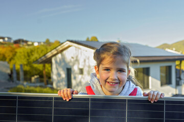 Little girl holding photovoltaics solar panel. Alternative energy, saving resources and sustainable...