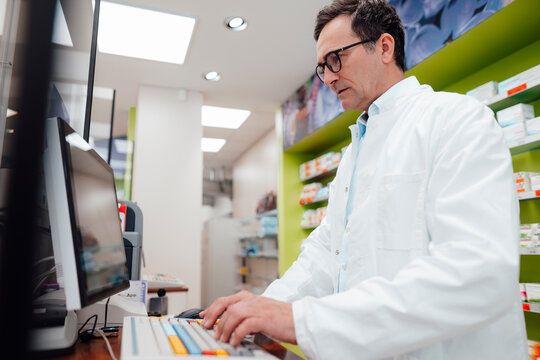 Pharmacist using desktop PC in store