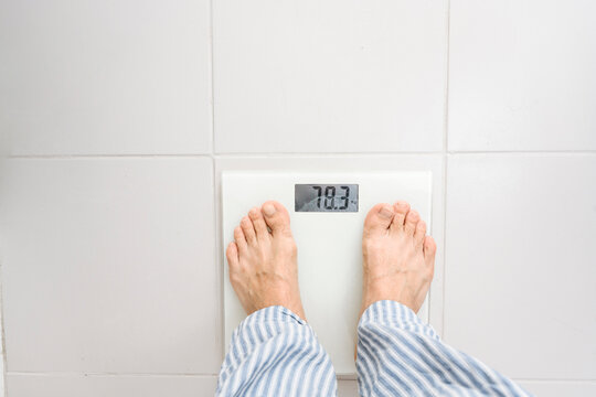 Man standing on weight scale at home