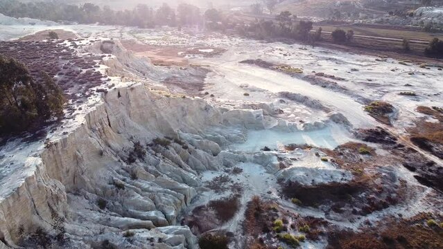 Aerial drone shot tracking backwards over an old gold mine dump where the tailings are being recycled using modern technology, Benoni, South Africa 