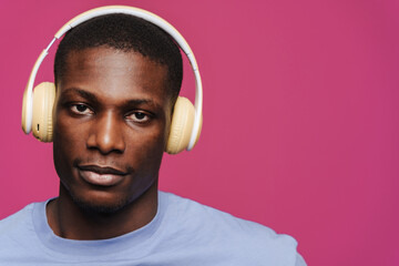 Black young man wearing t-shirt listening music with headphones