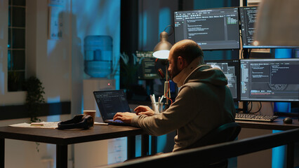 Database admin wearing cervical neck collar at web developing job, suffering from spinal injury at night. Young man with medical spine brace programming app language on terminal window.