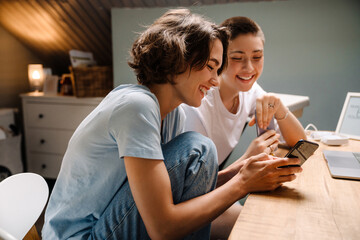 Young white women using mobile phone while sitting at desk