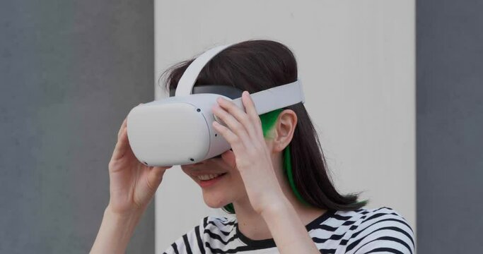 Experience VR. Young woman with virtual reality headset near building