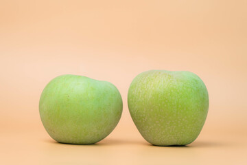 Fresh green apples on beige background.