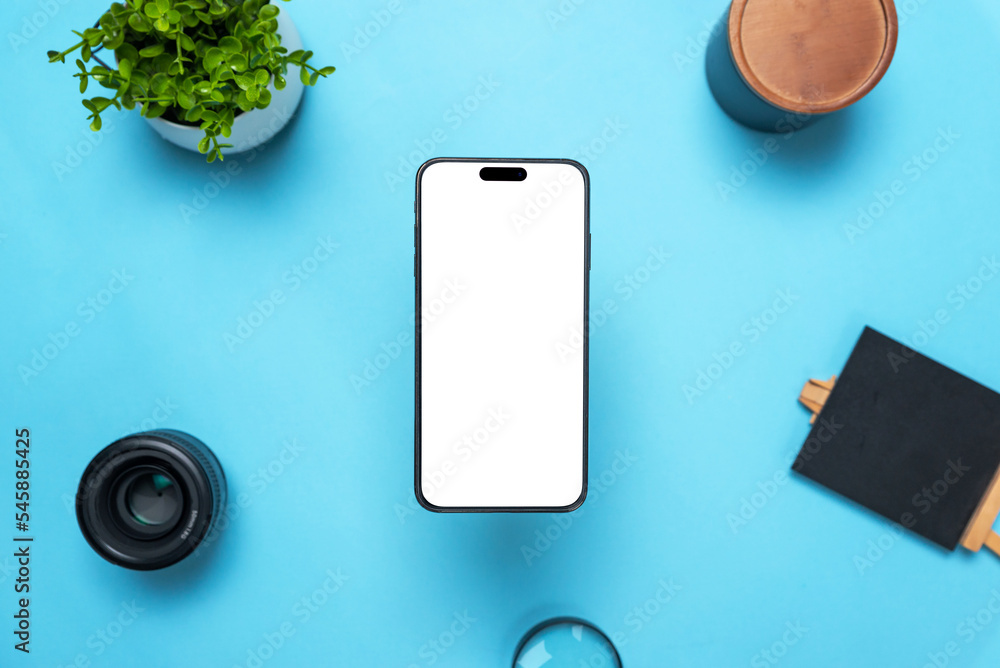 Aufkleber phone mockup above a desk with objects around. levitation above top view, flat lay composition. isol