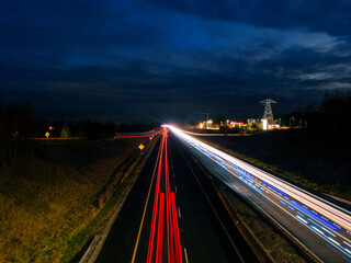 Car light trail on a free way in two directions. Dark blue sky. Transportation and commute concept.
