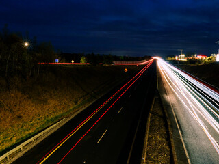 Car light trail on a free way in two directions. Dark blue sky. Transportation and commute concept.