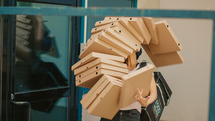Fastfood meal courier dropping pizza boxes pile outside building, clumsy takeaway worker stumbling...