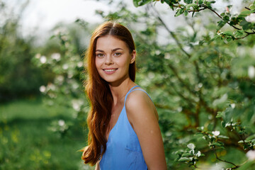 Woman smile with teeth happiness in nature in the summer near a green tree in the garden of the park, the concept of women's health and beauty with nature sunset