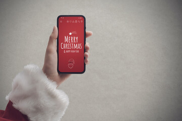 Fototapeta premium Santa Claus holding a smartphone