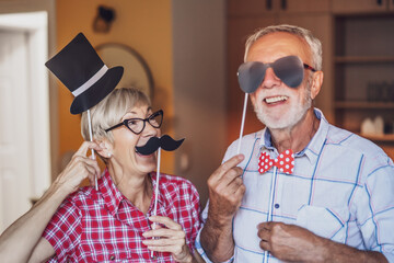 Happy mature couple is having fun at home.
