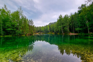 Picturesque turquoise water in a mountain lake in the forest.