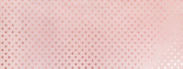 Obraz premium Light pink christmas background from metal foil paper with a pattern of sparkling stars, macro. Pastel rose backdrop.