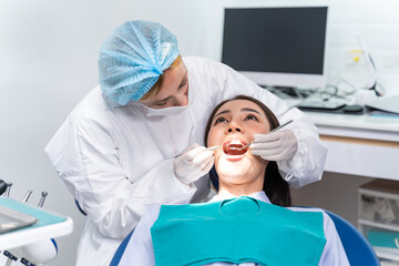 Caucasian dentist examine tooth for young girl at dental health clinic. 