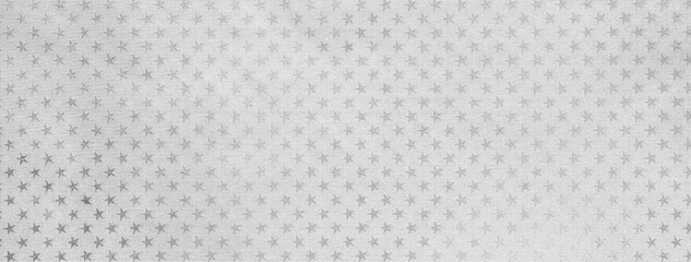 Light silver christmas background from metal foil paper with a pattern of sparkling stars, macro. Gray backdrop.