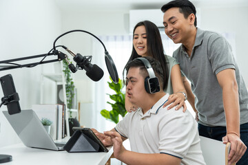 Fototapeta na wymiar Asian young DJ man speaking on microphone at studio with loving parent. 