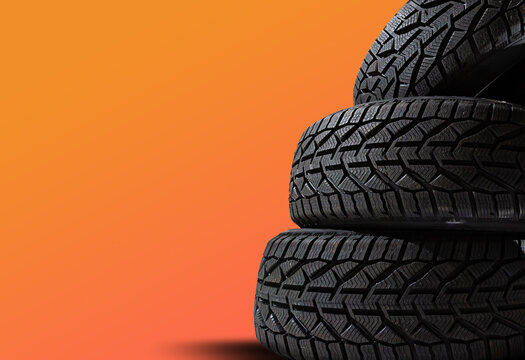 Stack of wheel new black tyres for winter car driving isolated on colored background