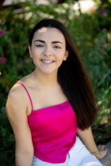 Portrait of a happy lovely and beautiful Spanish young woman in a park.