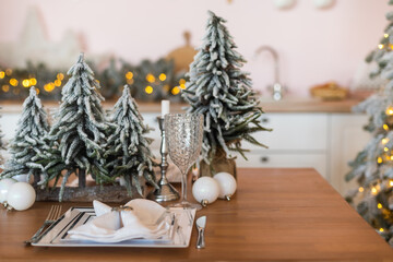 Wooden tabletop with cutting board and blurred kitchen with Christmas tree. Background for display or montage your products